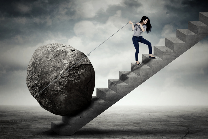 Image of beautiful female entrepreneur carrying big stone with a chain on the stair